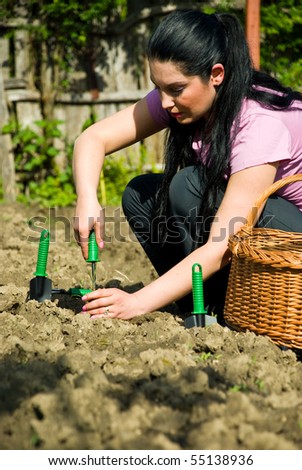 Young woman working in garden and using tools  at countryside