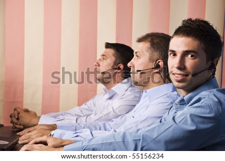Customer service team with men in office,first man facing you and smiling
