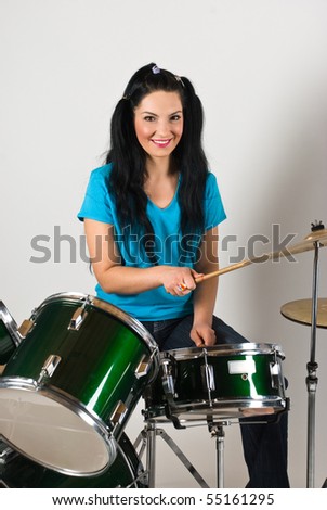 Young woman drummer  playing music on drum set