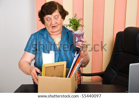 Elderly woman 80s years retired from activity,she holding a box with her goods and leave the office