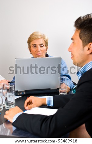 Senior executive woman using laptop in the middle of a business meeting