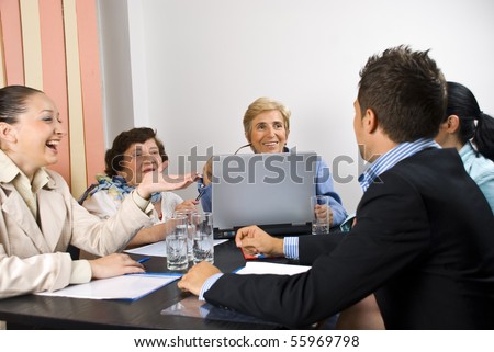 Business people having funny conversation at meeting and they smiling and laughing together,selective focus on senior blond woman