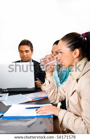 Two business woman drinking water at a meeting  and sitting in  profile