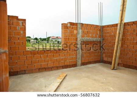Interior of a house under construction with red brick walls