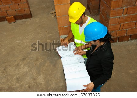 Top view of two construction workers people looking on projects in a house under construct