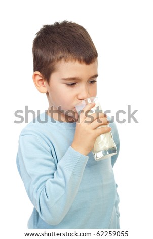 Child boy standing in semi profile and drinking a glass of milk isolated on white background
