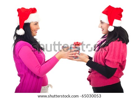 Woman offering Christmas gift to her friend and both smiling isolated on white background