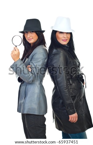 Two beautiful detectives women standing back to back and wearing hats and leather jackets  isolated on white background