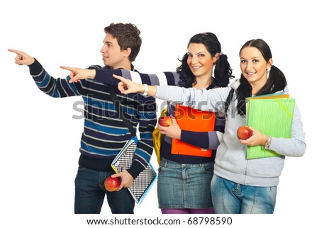 Group of three students in a row pointing to copy space left side isolated on white background