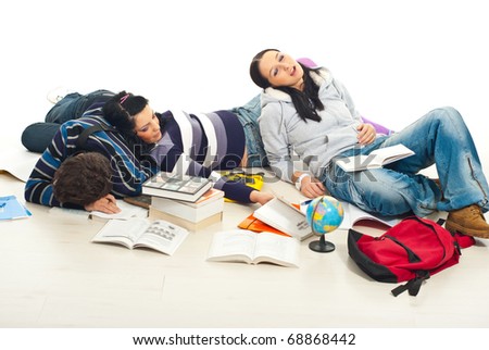 Three tired students fall asllep on floor with books and notebooks around them in a  house