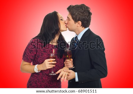 Kissing couple on Valentine\'s  day ,man holding her hand with wedding ring and toasting with champagne on red background