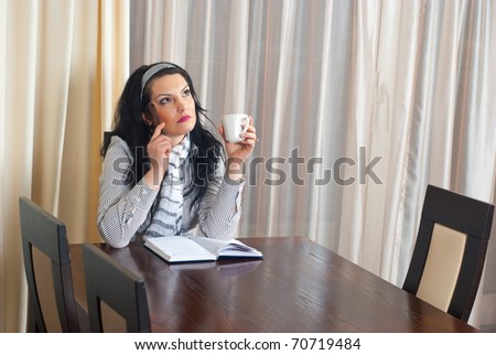 Thinking executive woman sitting on chair at table meeting  and holding a cup of coffee