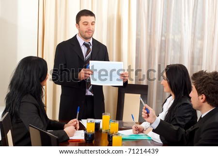 Business man showing a graphic at meeting and discuss with his colleagues