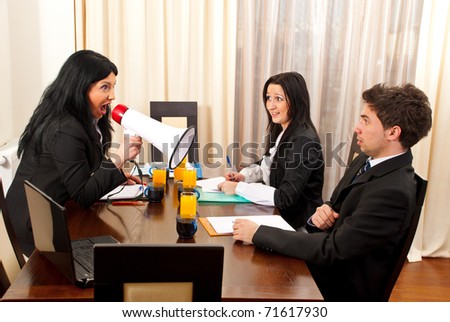 Crazy manager woman shouting in megaphone to employee man in a office