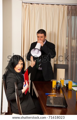 Nervous chief man with megaphone shouting to amazed business woman with stop hand