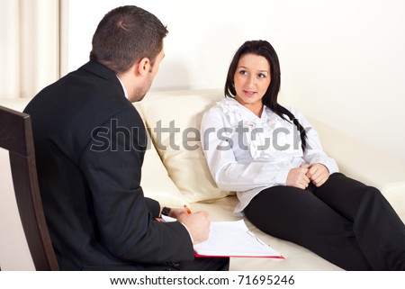 Patient woman  sitting on couch and talking with psychologist man