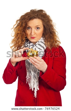 Sad woman in autumn jacket gesturing and showing a small piggy bank isolated on white background