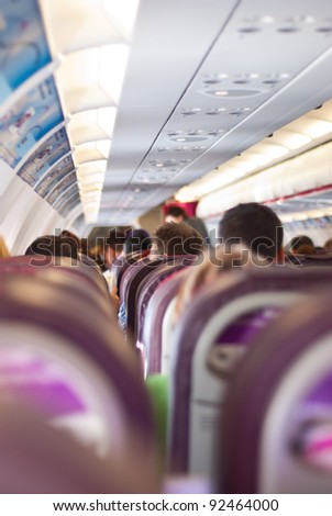Passengers sitting on their chairs in airplane cabin