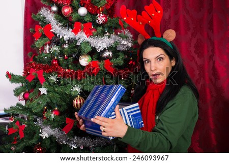 Amazed woman opening Christmas gift  home