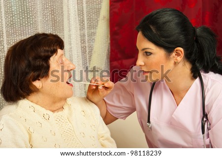 Doctor woman examine elderly patient for sore throat in her house