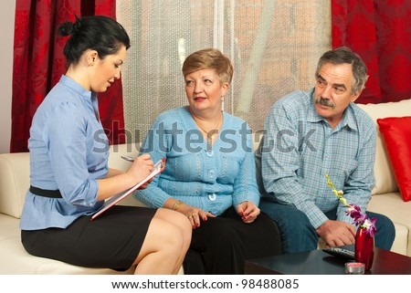 Financial consultant having conversation with mature couple in their house