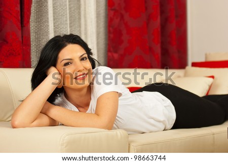 Happy woman laying on sofa in her living room
