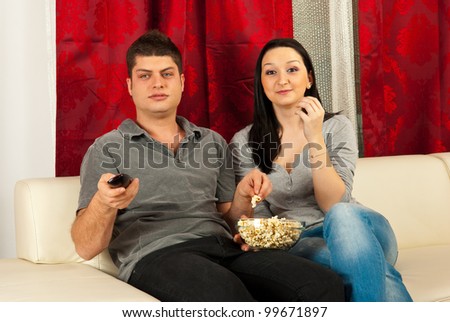 Couple watching movie at tv and eating popcorn