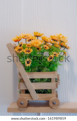 beautiful artificial flowers in wood car shape basket