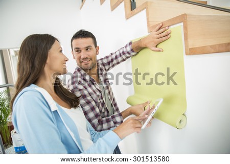 young couple choosing new pent paper with tablet pc