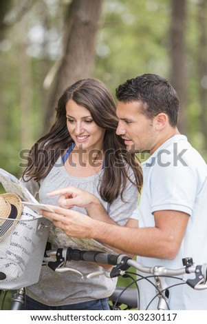 young couple with map and bike