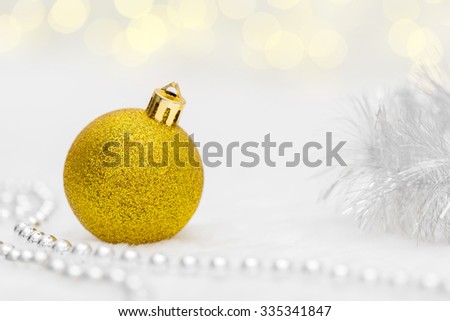 Golden Christmas ball with beads. Bokeh with glow effect on white background.