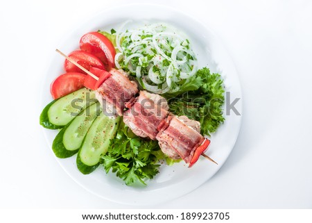 skewers wrapped in bacon with tomatoes, cucumbers, bell peppers