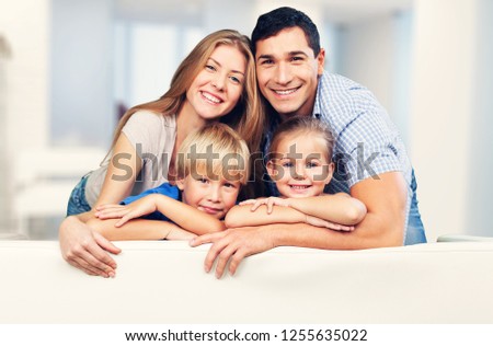 Beautiful smiling family sitting at sofa at home