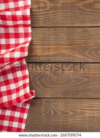 old wooden table with red picnic tablecloth and copyspace
