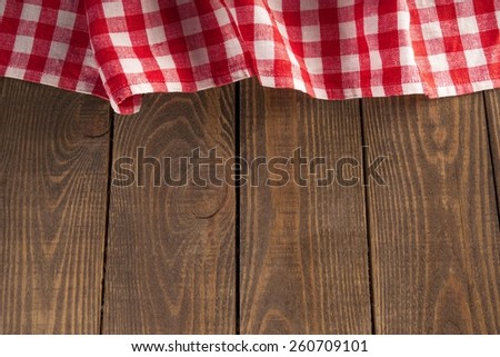 old wooden table with red picnic tablecloth and copyspace