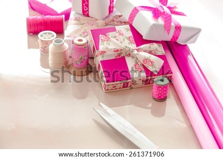 Christmas present wrapping background, wooden vintage ribbons spools and gift boxes and wrapping paper rolls
