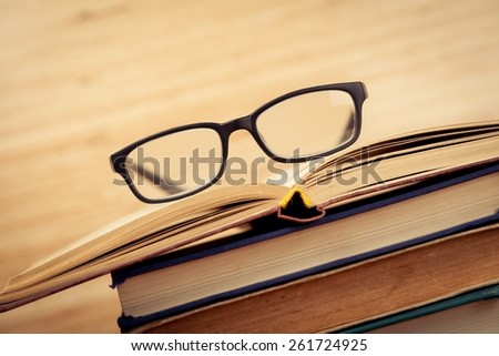 Analyze. picture of a pile of books and eyeglasses, with a retro effect