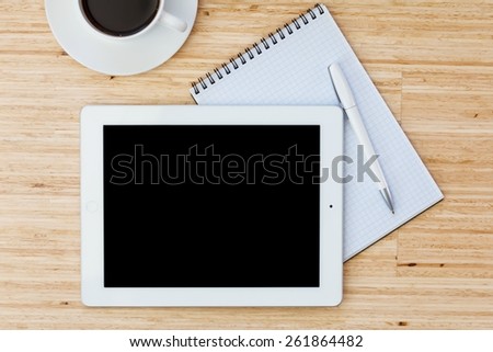 Ipade. digital tablet and cup of coffee on wooden table