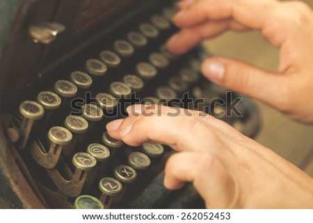 Alphabet. Hands writing on old typewriter