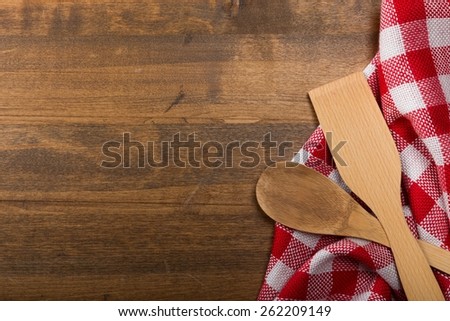 Cloth. Serving spoons on checkered cloth lying on wooden surface
