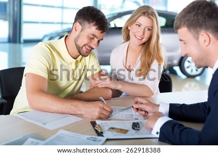 Car. Couple completing paperwork in car showroom