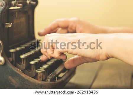 Alphabet. Hands writing on old typewriter