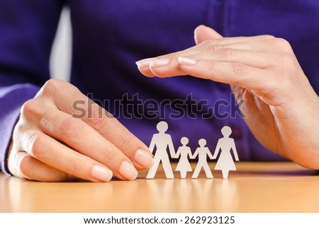 Protection. a female hand protecting a paper chain family