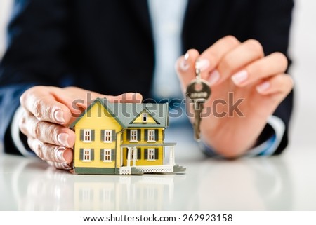 Realtor. Real estate agent with house model and keys