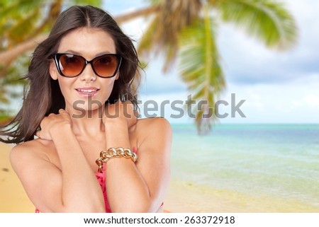 Attractive. Vivacious sexy young brunette woman with a beautiful smile and her hair blowing in the breeze posing in a white bikini  three quarter isolated studio portrait