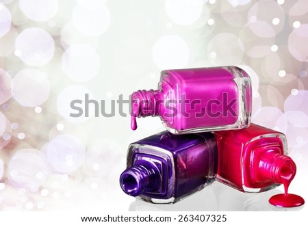 Accessory. Bottles with spilled nail polish over white background