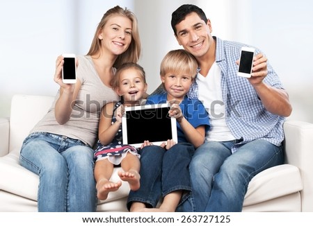 Phone. Family, child, technology and home concept - smiling parents and little girl with blank black screen smartphones at home