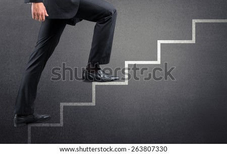 Step. Businessman climbing the career stairs drawn on a chalkboard with copy space