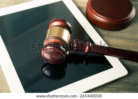 Law. Judge gavel and tablet computer on table cyber crime concept