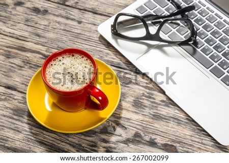 Glasses. Cup of coffee and laptop with a pair of hipster glasses on wooden table toned with a retro vintage instagram filter